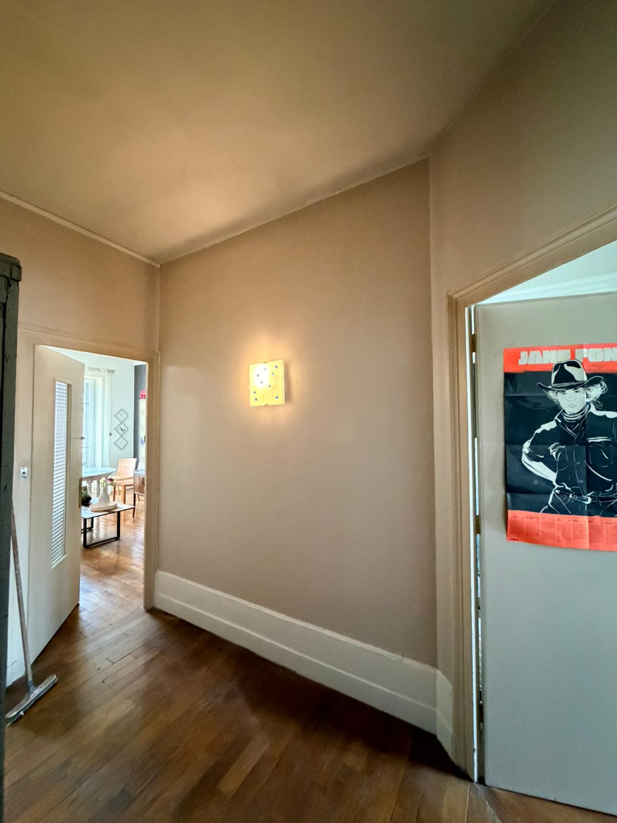 Photo d'un couloir dont les plinthes sont neuves et les murs repeints.