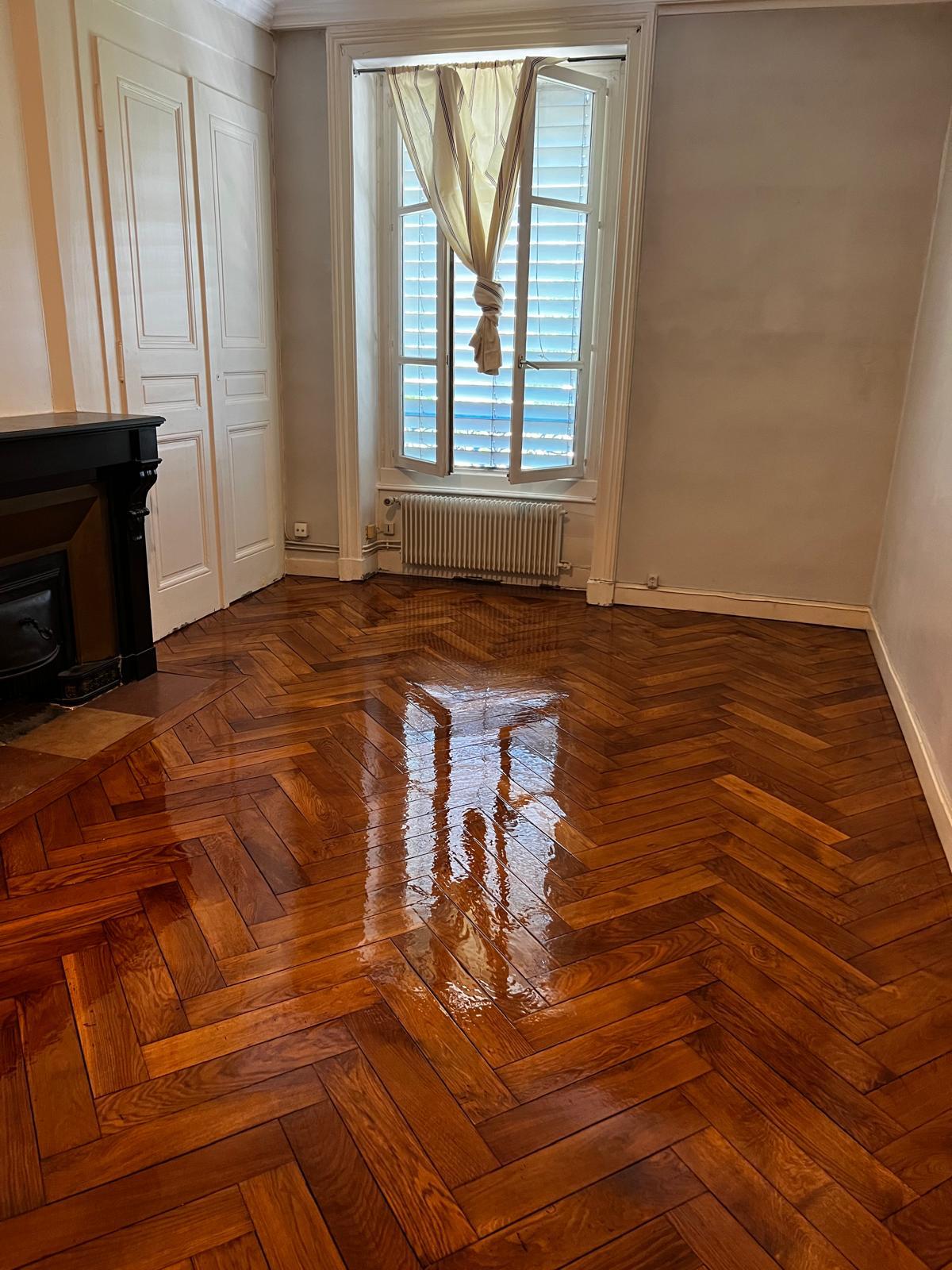 Photo d'un séjour d'un appartement de style ancien où le parquet chevron a été rénové.