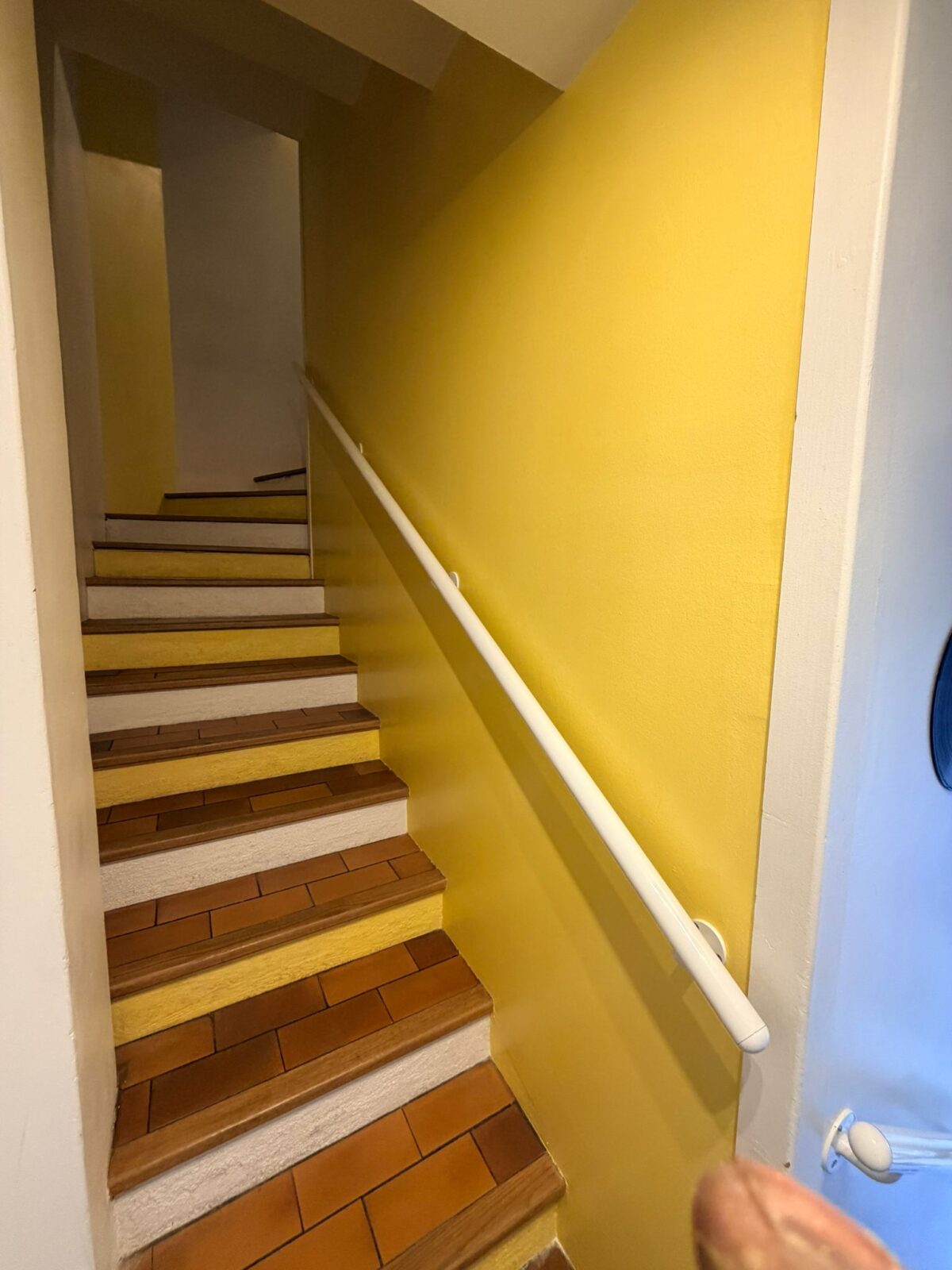 Photo d'une cage d'escalier d'un immeuble récemment repeinte en jaune.