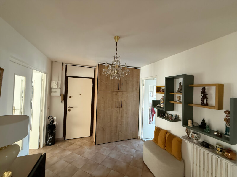 Photo de l'entrée d'un appartement avec un grand placard et des décorations murales.