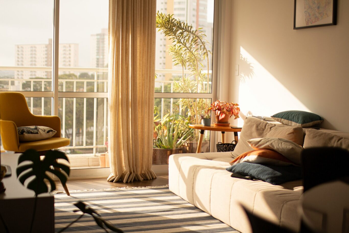 Photo du salon d'un appartement moderne inondé par la lumière extérieure.