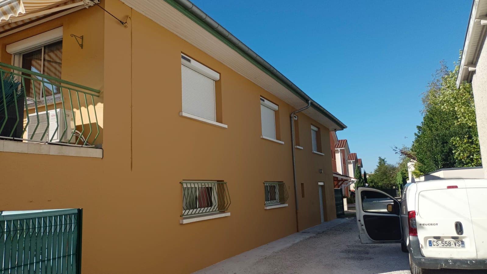 Photo d'une façade d'un immeuble qui vient d'être rénovée de couleur ocre.