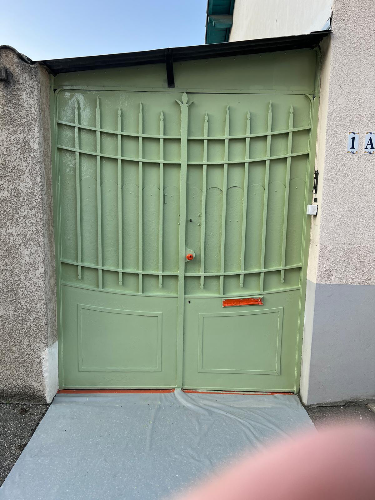 Portail métallique qui a été repeint de couleur sauge.