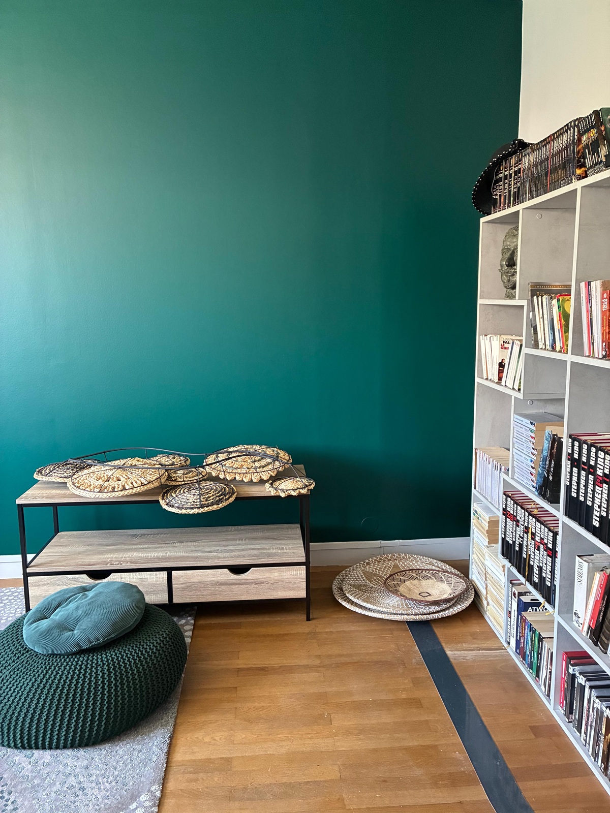Photo d'un mur de couleur bleu canard avec une bibliothèque à droite.