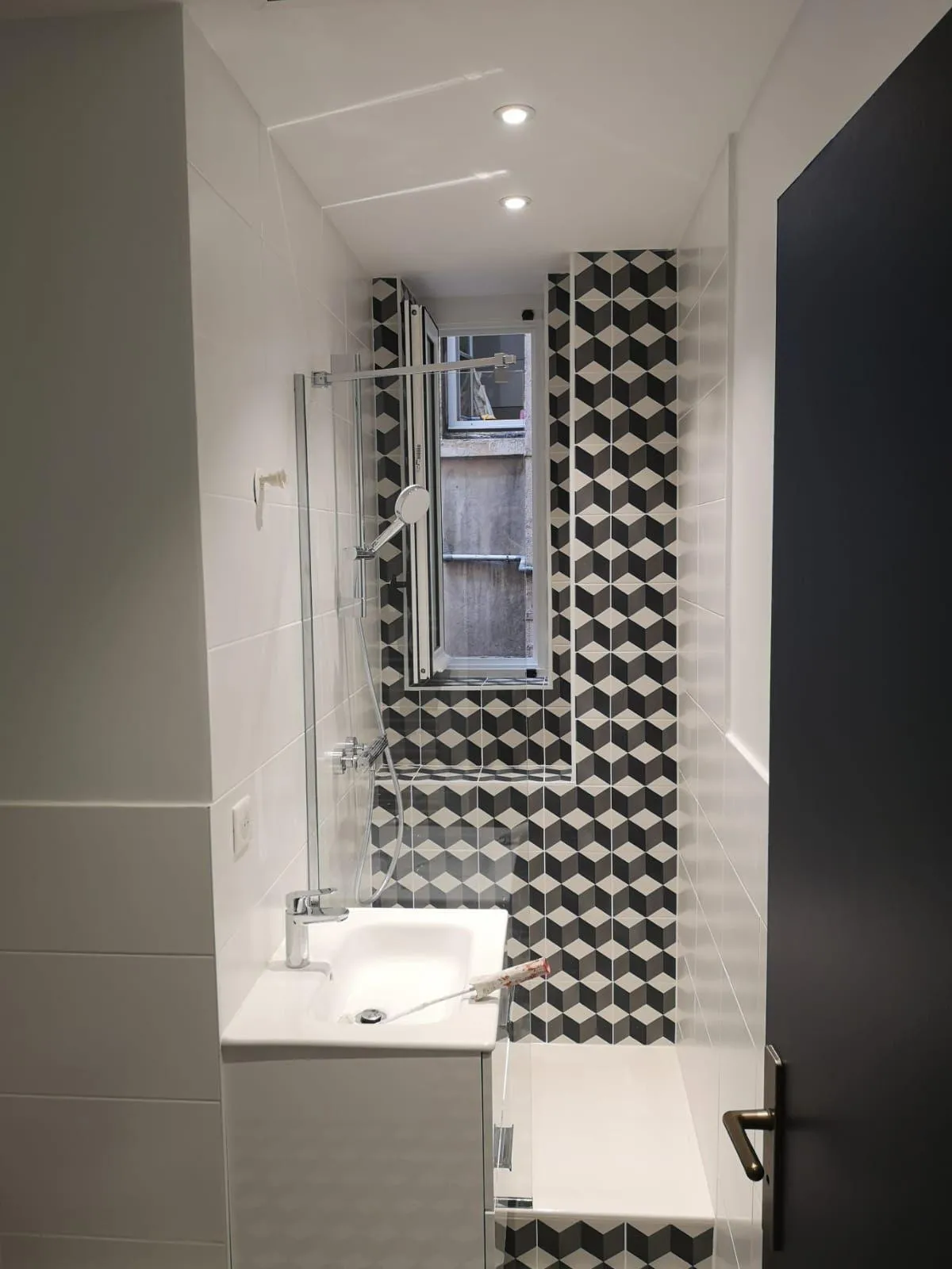 Photo salle de bains chic avec des murs blancs et un carrelage rétro noir.
