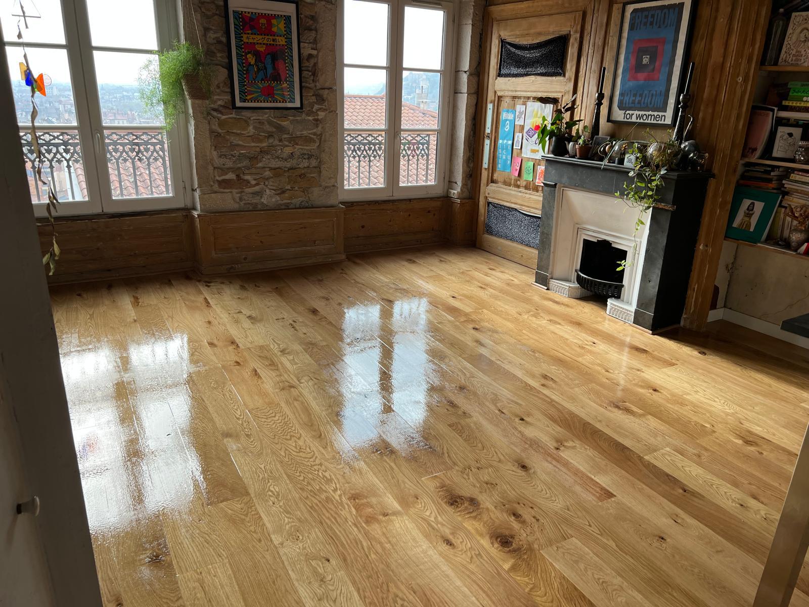 Photo d'un séjour d'un appartement haussmannien dont le parquet de chêne à grandes lattes a été ciré et lustré.
